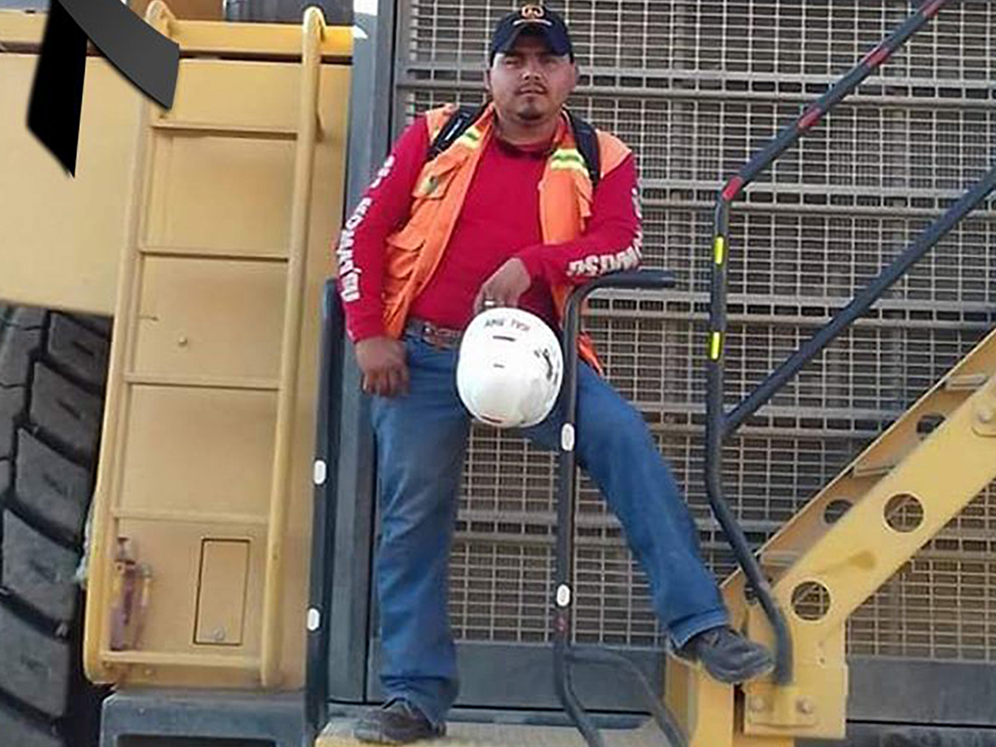 Worker on some steps holding a hard hat